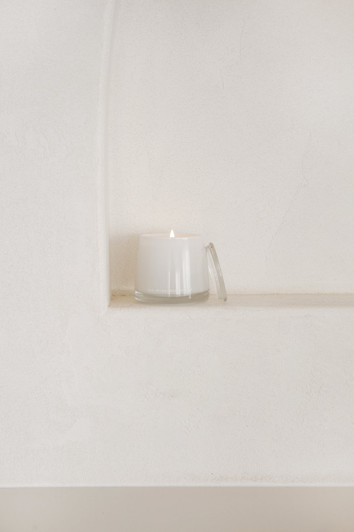 Therapy candle on a white wall niche shelf
