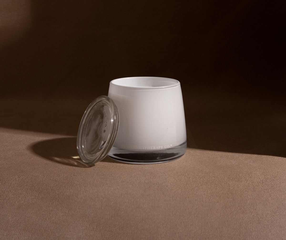 Therapy candle on dark timber in dramatic shadow