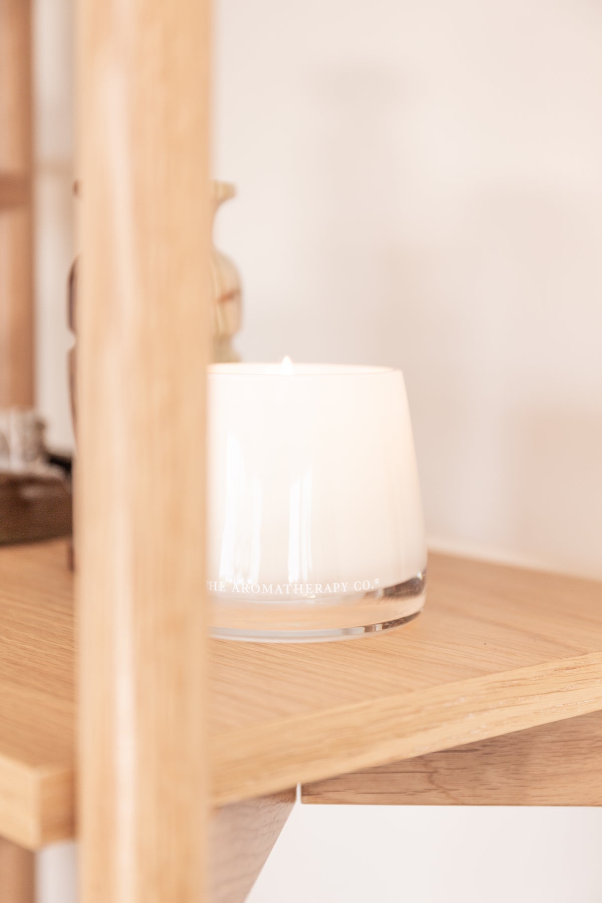 Therapy candle glowing on an oak shelf