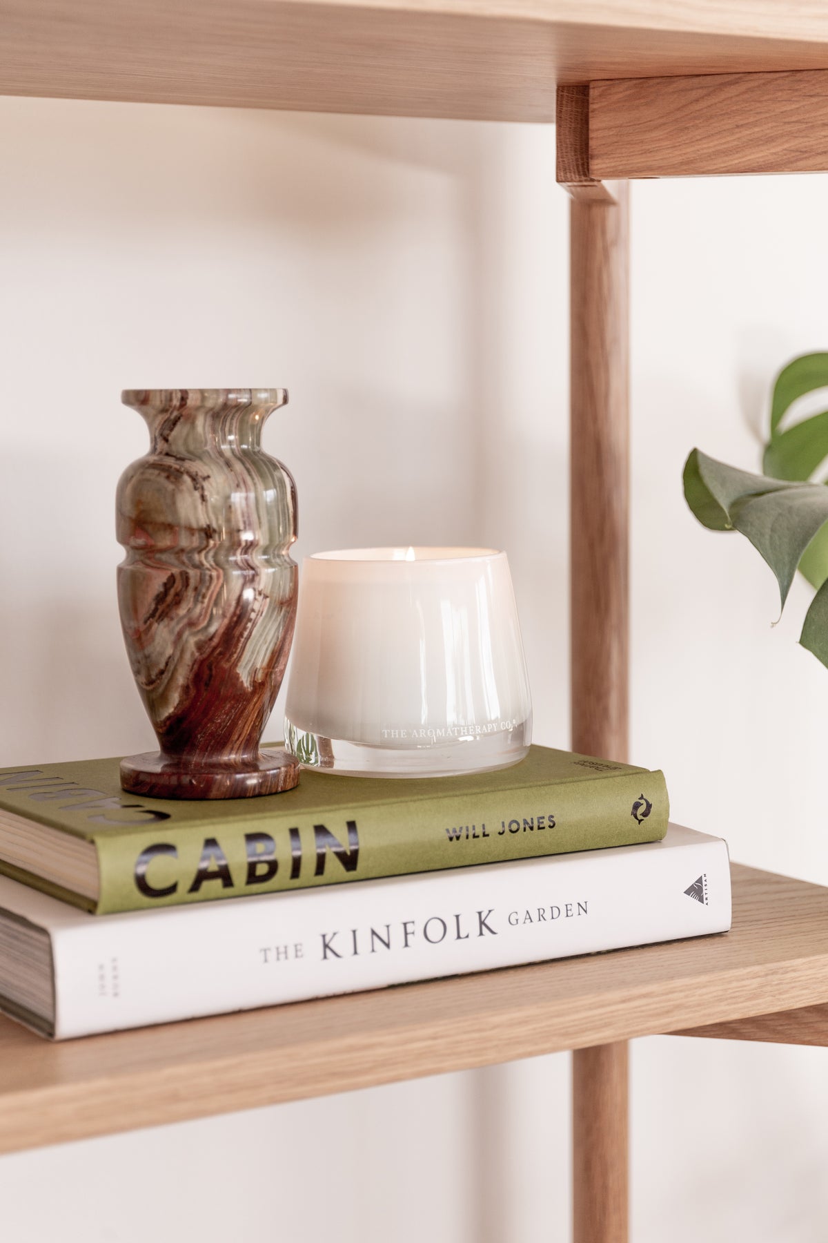 Therapy candle on an oak shelf with books and a patterned vase