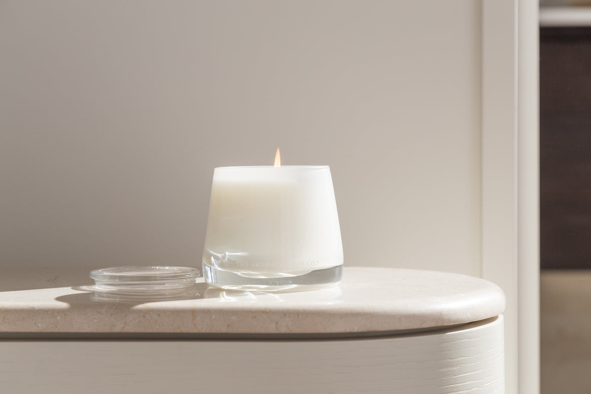 Therapy candle on a pale curved sideboard in soft light