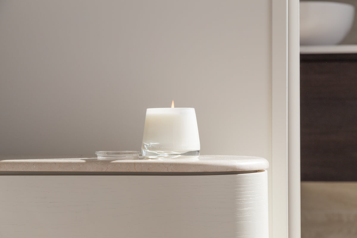 Therapy candle on a curved pale sideboard