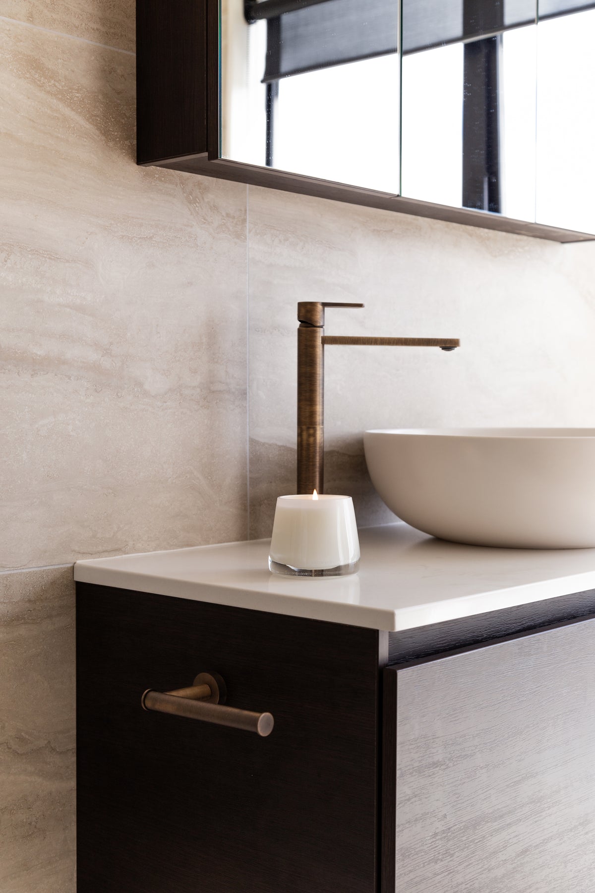 Therapy candle on a bathroom vanity with a dark tap