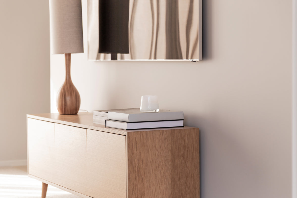 Therapy candle on a timber sideboard beneath a mirror