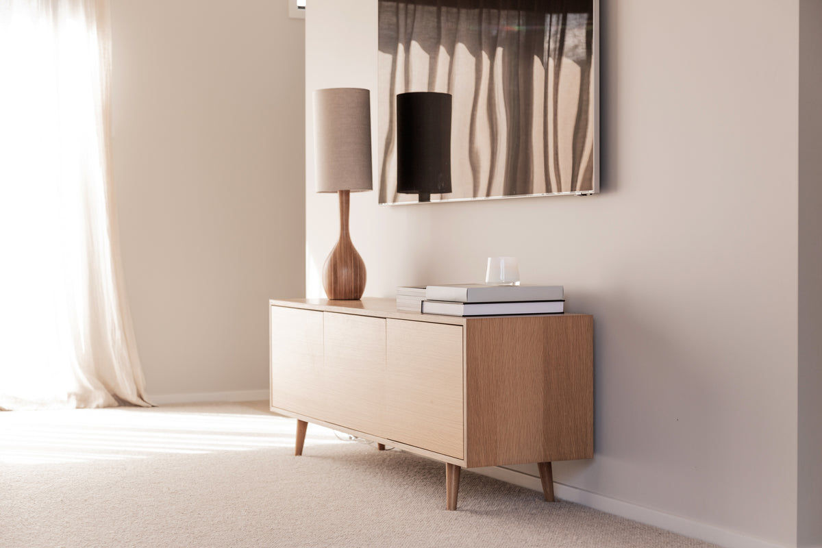 Therapy candle on a low timber cabinet in a bright living room