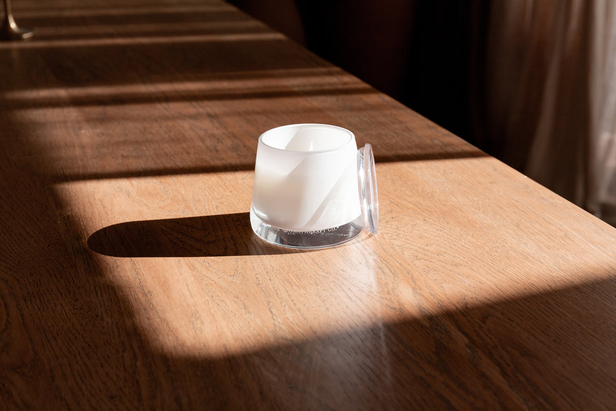 Therapy candle in a strip of sunlight on dark timber