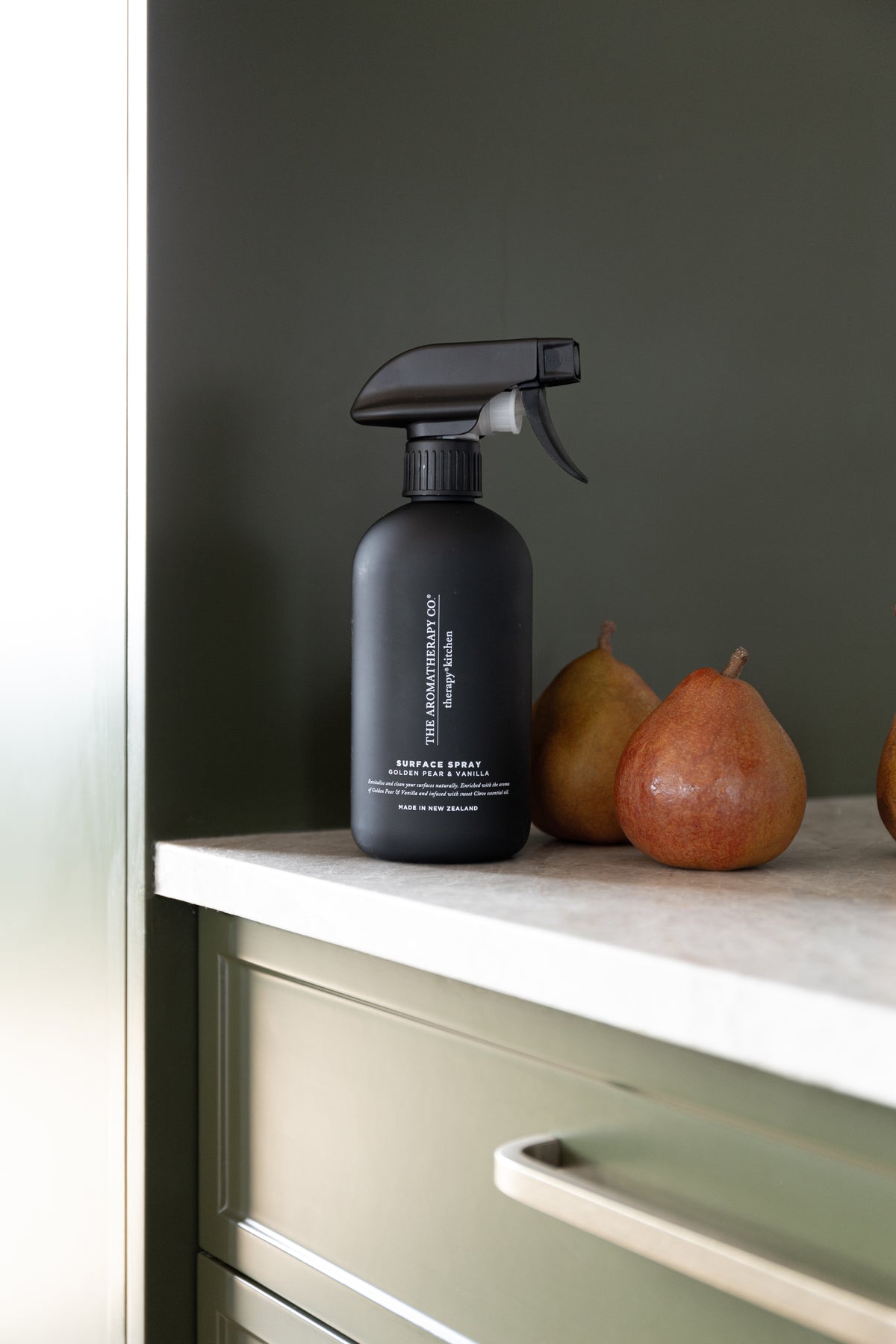 Close view of the black surface spray beside pears on a stone benchtop
