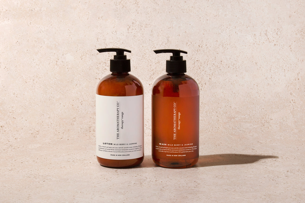 Two amber Therapy pump bottles side by side against a plain stone backdrop