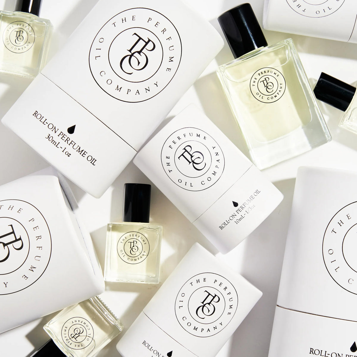 Flat lay of roll-on perfume oil bottles and white tube cartons