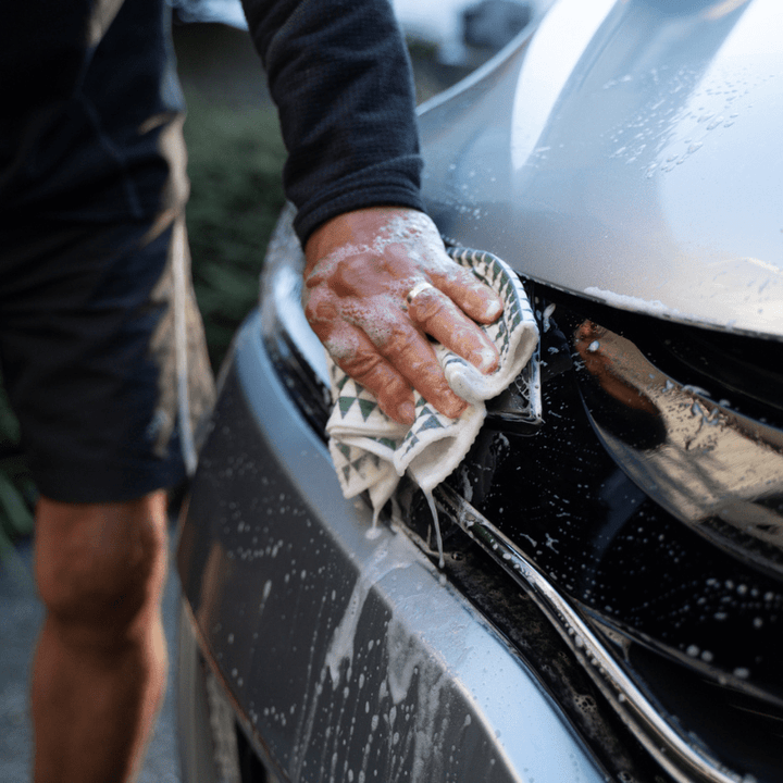 A man cleaning his car with a Good Change ECO CLOTH - LARGE (2-PACK).