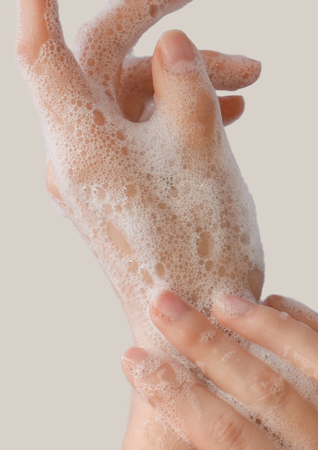 Close view of lathered hands washing with soft white foam