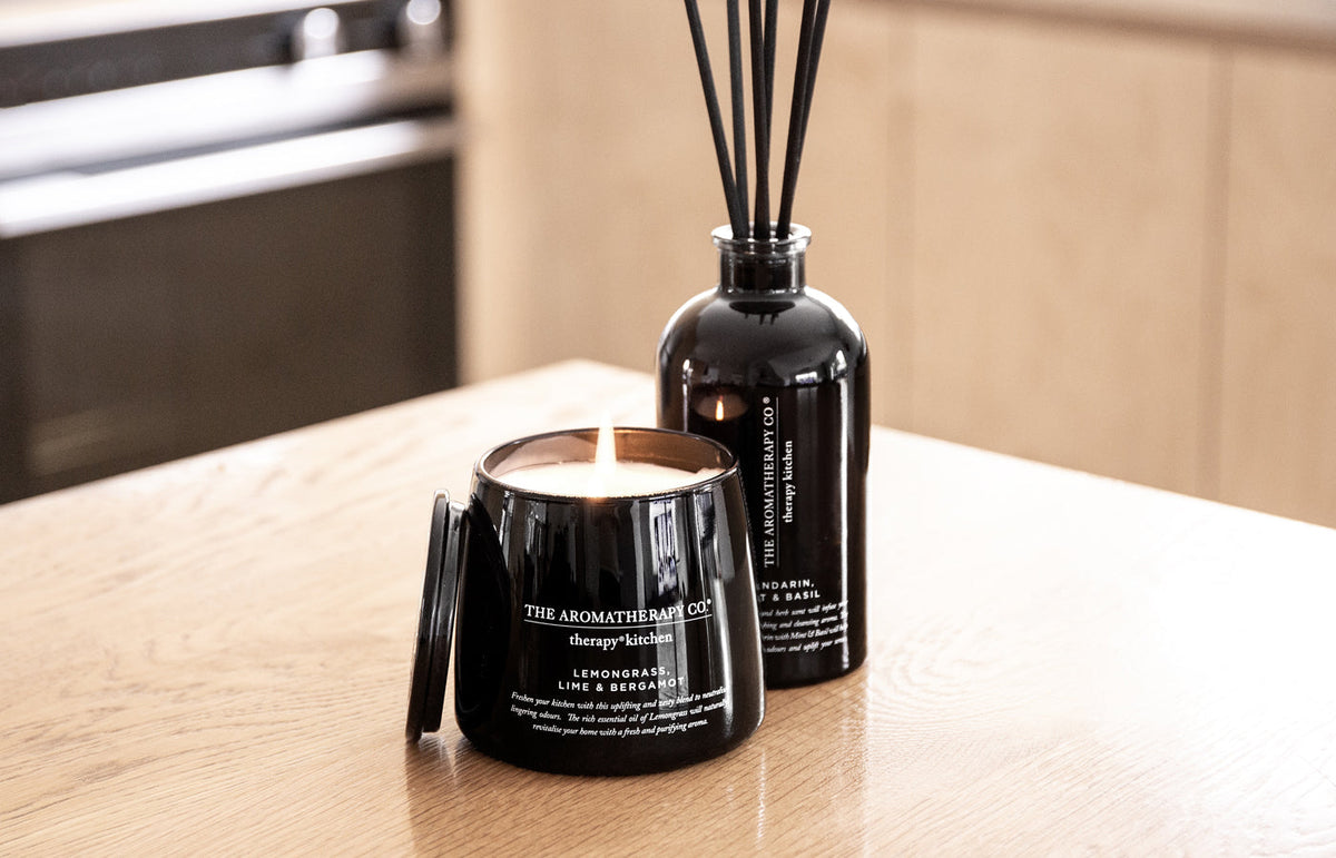 Wide view of the Therapy Kitchen candle and reed diffuser on a timber kitchen bench