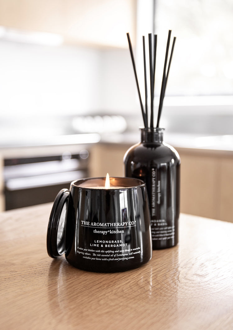 Therapy Kitchen Lemongrass, Lime & Bergamot diffuser beside the matching black candle on a kitchen bench
