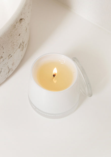 Close view of a lit Therapy candle on pale stone