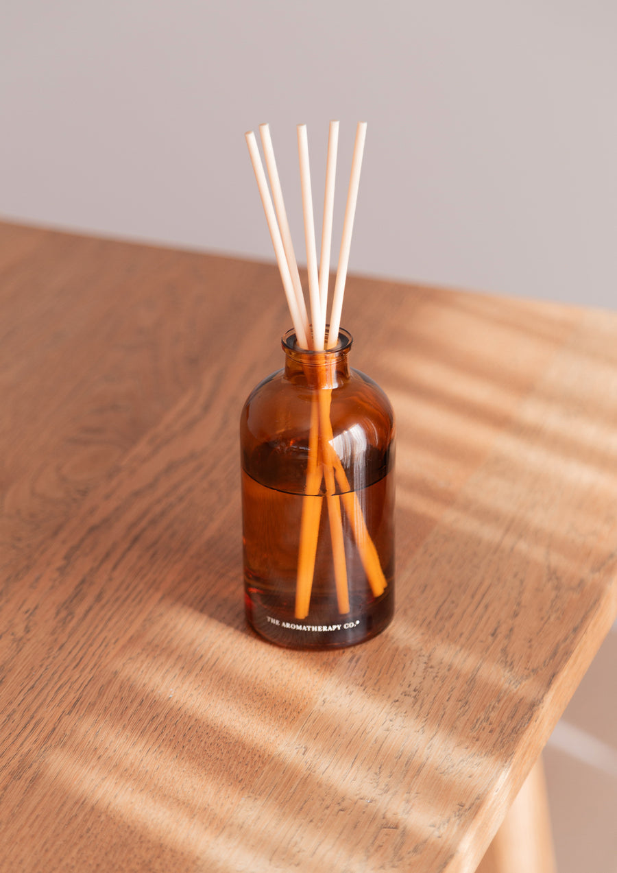 Therapy amber diffuser on a timber console in striped light
