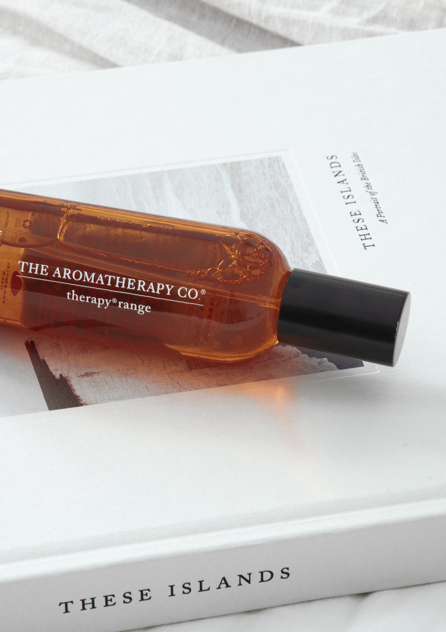 Close up of the amber spray bottle resting across an open coffee table book