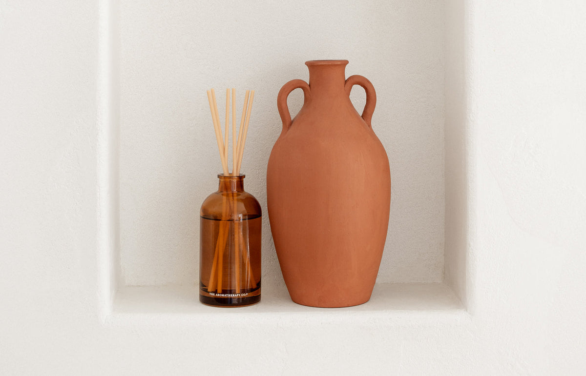 Terracotta vases on a pale shelf
