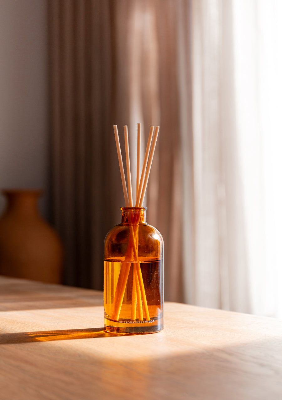 Therapy reed diffuser on a timber table in warm window light