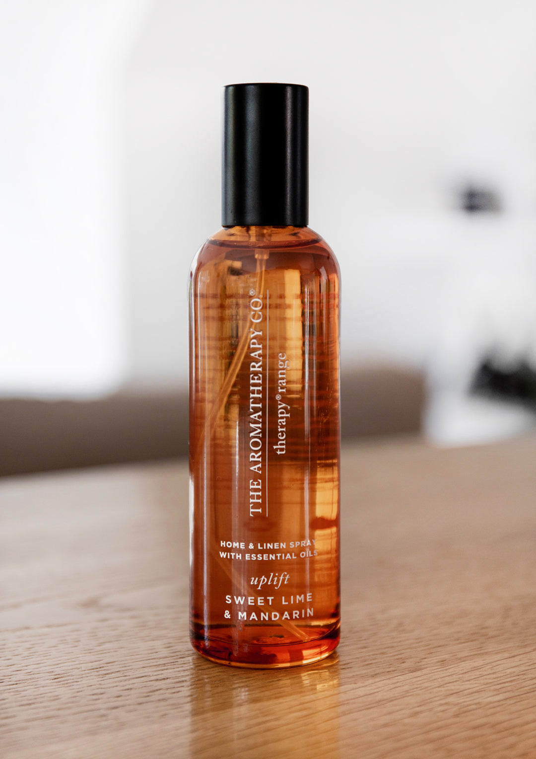 Therapy Sweet Lime & Mandarin room spray on a timber table in soft window light