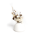 A white Harmie Vase - Beau with dried flowers in it, crafted by Vietnamese artisans from Ned Collections.