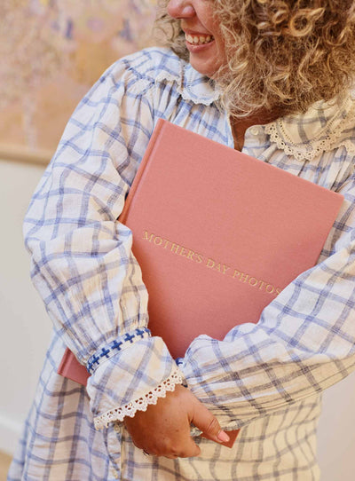 Person holding the blush linen photo journal against their chest