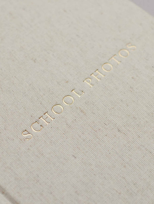 Close-up of the gold embossed School Photos title on oatmeal linen