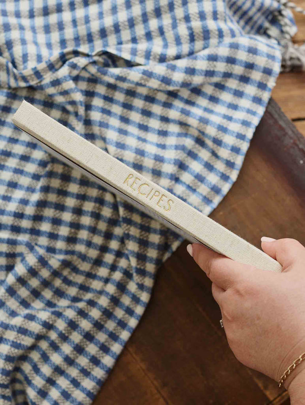 Hand holding the oatmeal recipe journal to show its spine