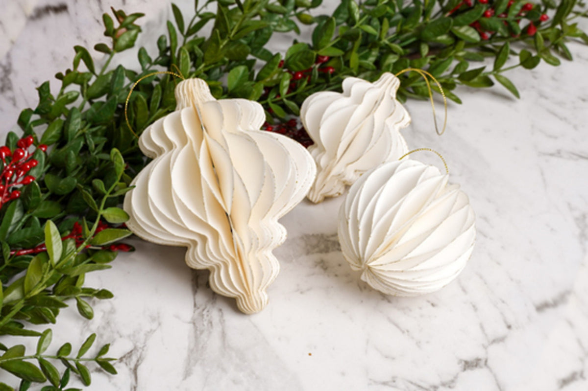 Off-white paper finial decorations with greenery on marble
