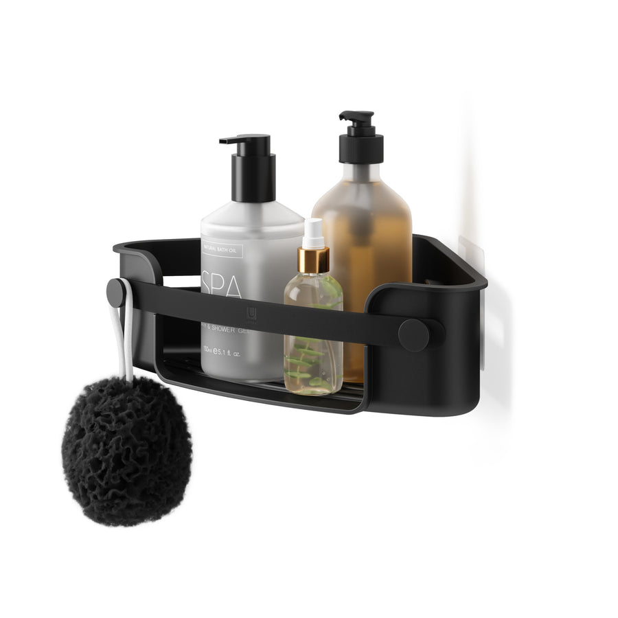 Umbra Flex adhesive corner bin in black with bath bottles and a sponge on the knob