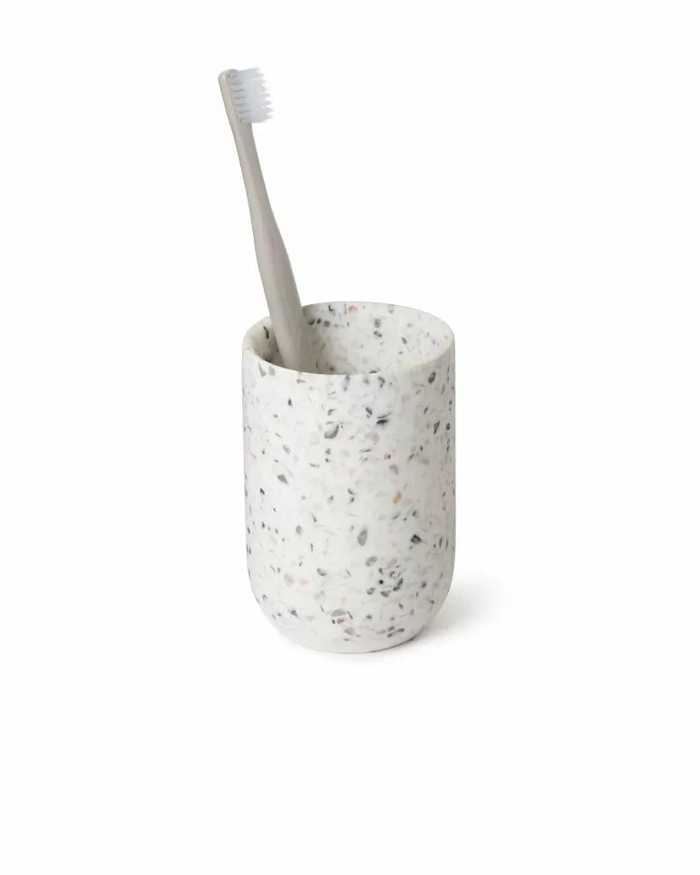 Umbra Junip bathroom tumbler in terrazzo grey holding a toothbrush
