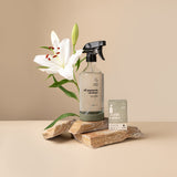 All-purpose reusable glass spray bottle with silicone base on a benchtop