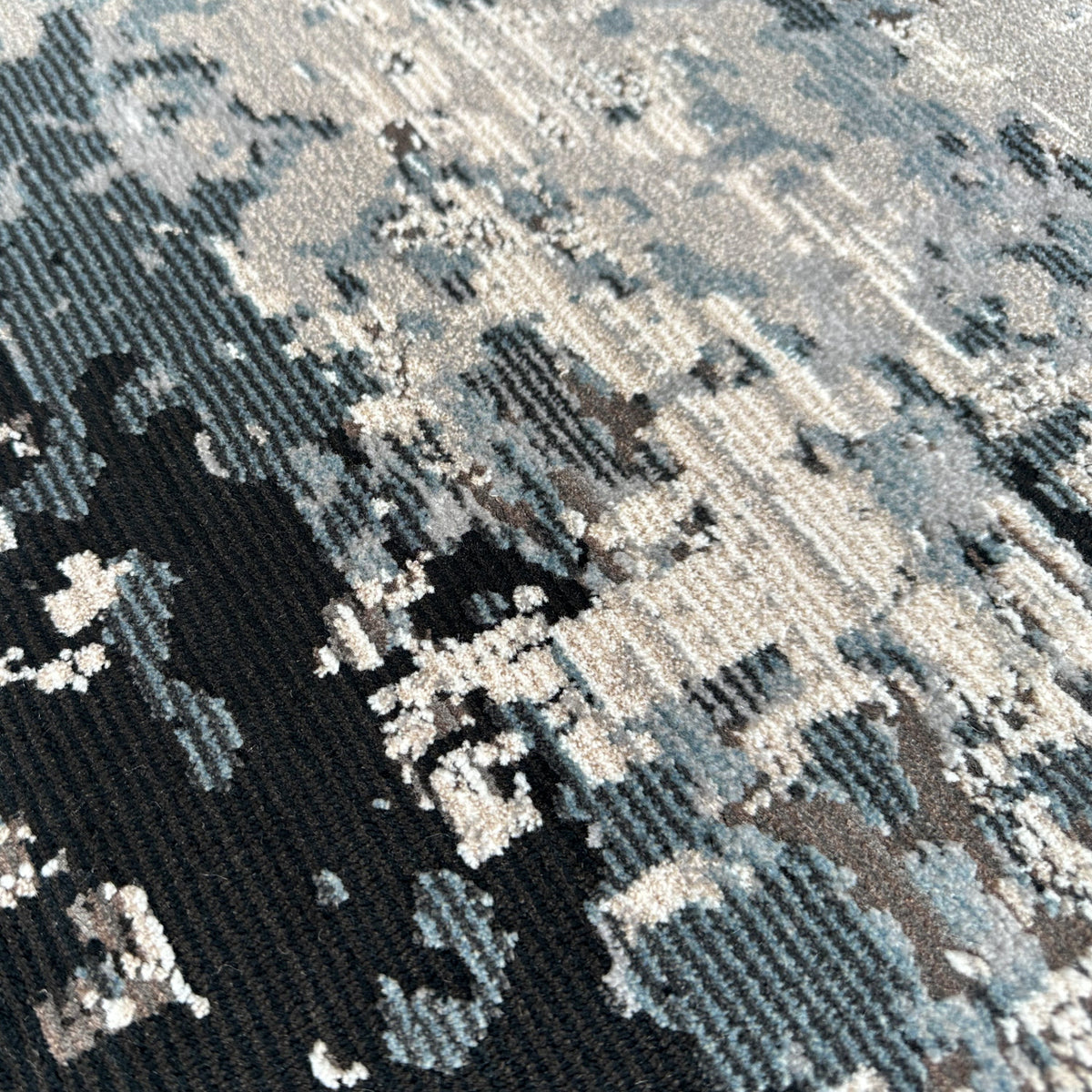 Close view of the low pile with patches of grey, ivory and charcoal