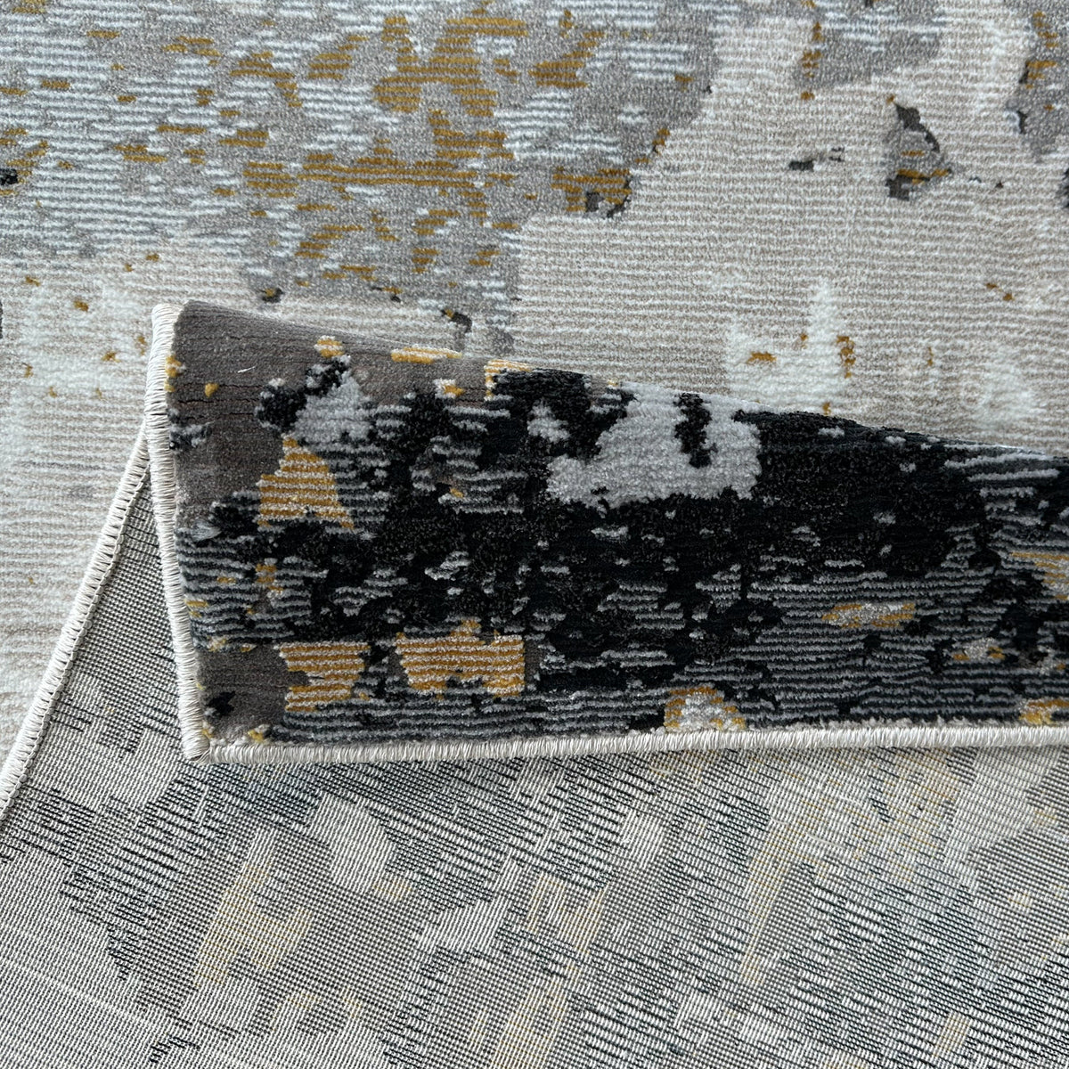 Folded corner of the abstract rug showing the low pile and backing