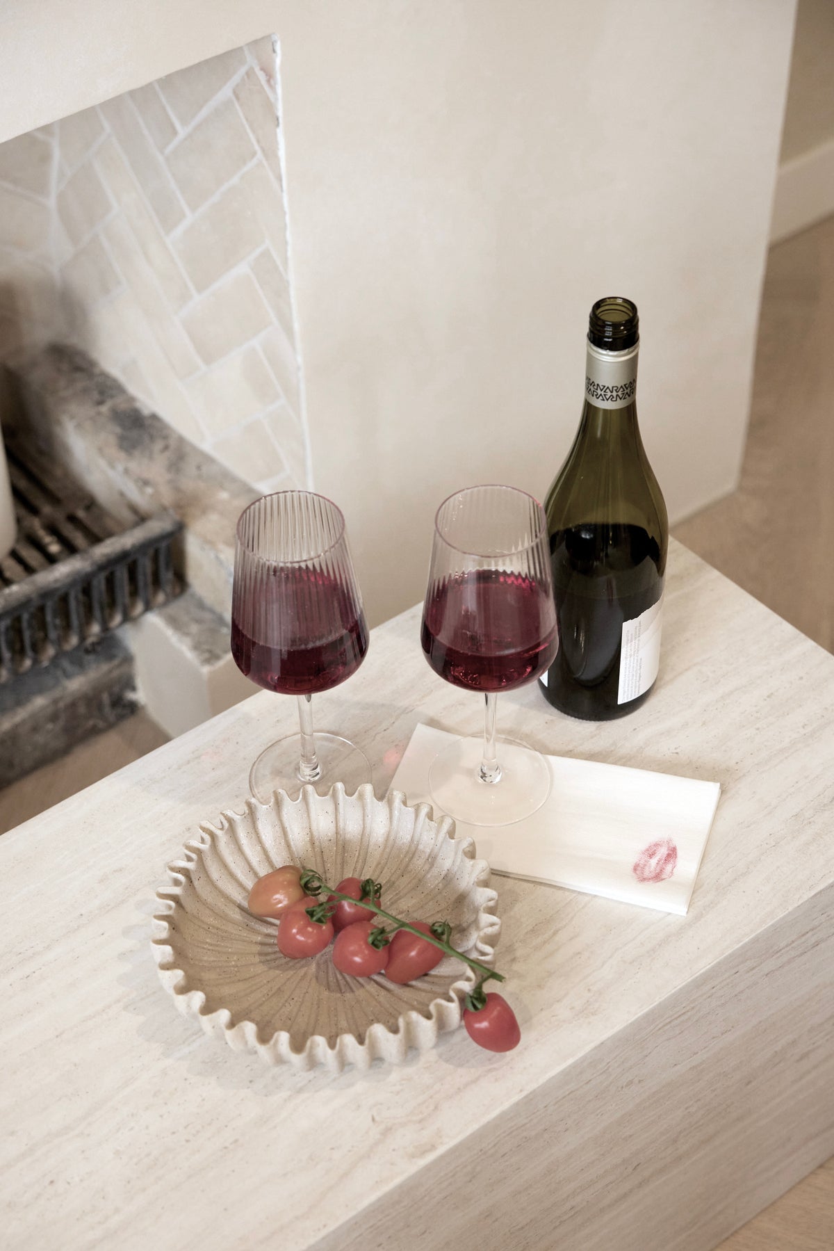 Amalfi fluted wine glasses of red wine beside a scalloped bowl of strawberries