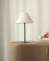 Arch Table Lamp with linen shade styled on a timber sideboard beside books and a cup