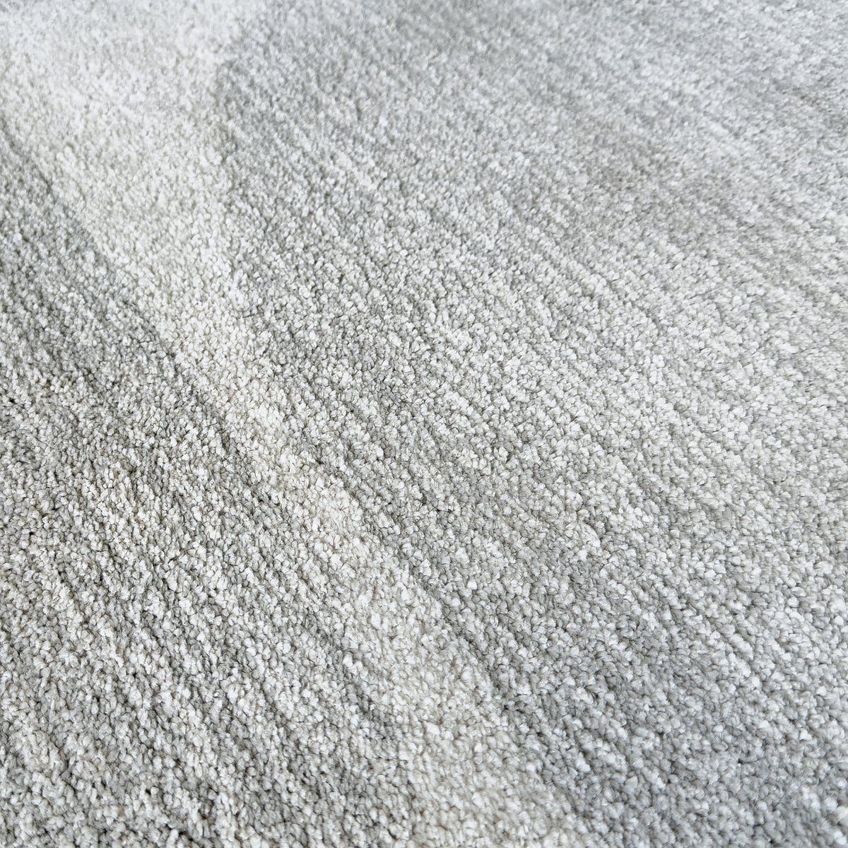 Close view of the grey pile where a lighter arch crosses the design