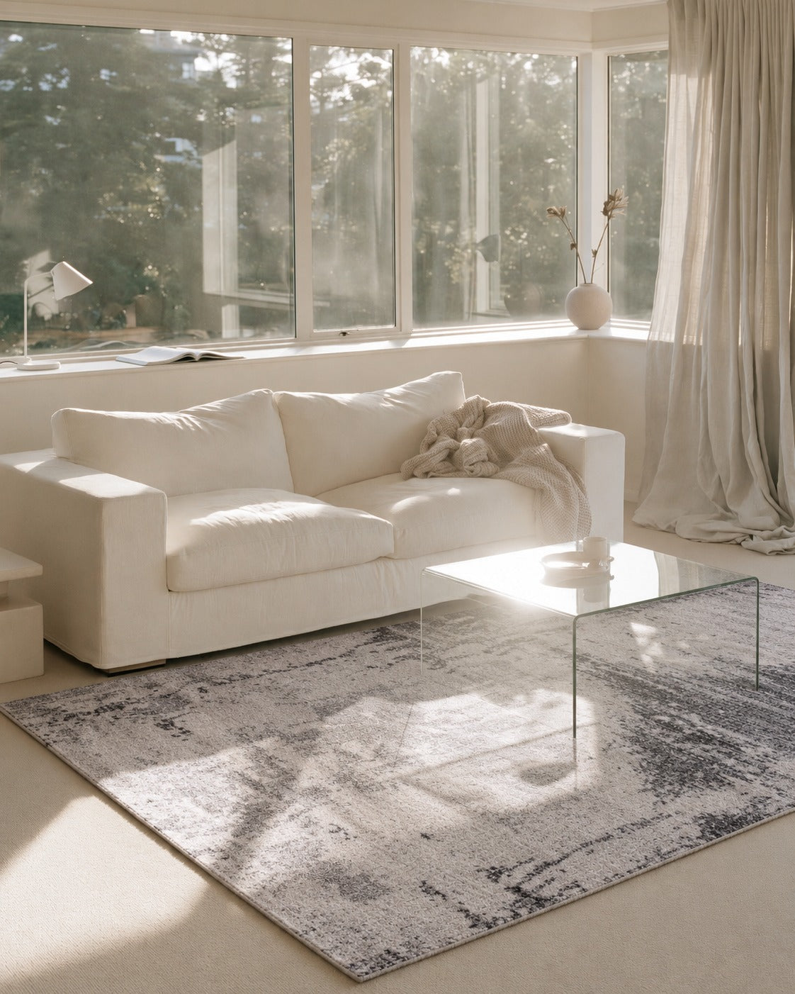 Asana Vintage Light Grey and Black Rug in a sunlit lounge with a white sofa and glass coffee table