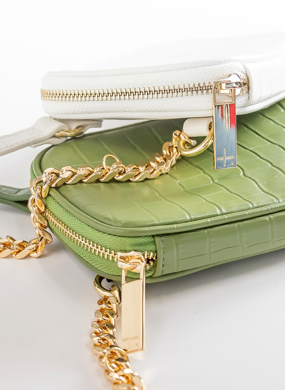 Close view of Attached To Me bags in ivory and olive green croc-embossed leather with gold chains