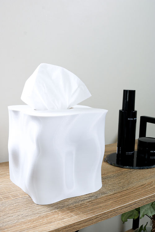 An Ebb Tissue Box cover made from recycled PLA plastic, sitting on a wooden table. (Brand: Utilize Studios)