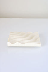 A recycled Ripple Soap Tray by Utilize Studios with a wave pattern on it.