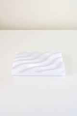 A Ripple Soap Tray made from recycled PLA plastic and featuring a wave pattern, created by Utilize Studios.
