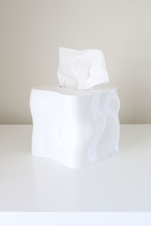 White Ebb tissue box cover with a tissue drawn up, on a white table