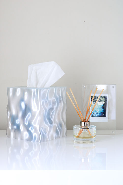 A Flow Tissue Box, made from recycled materials and featuring a picture on it, placed on a table. (Brand: Utilize Studios)