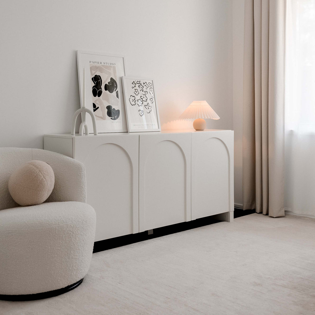 Belle Femme and Fleurs prints on a white arched sideboard in a soft neutral living room