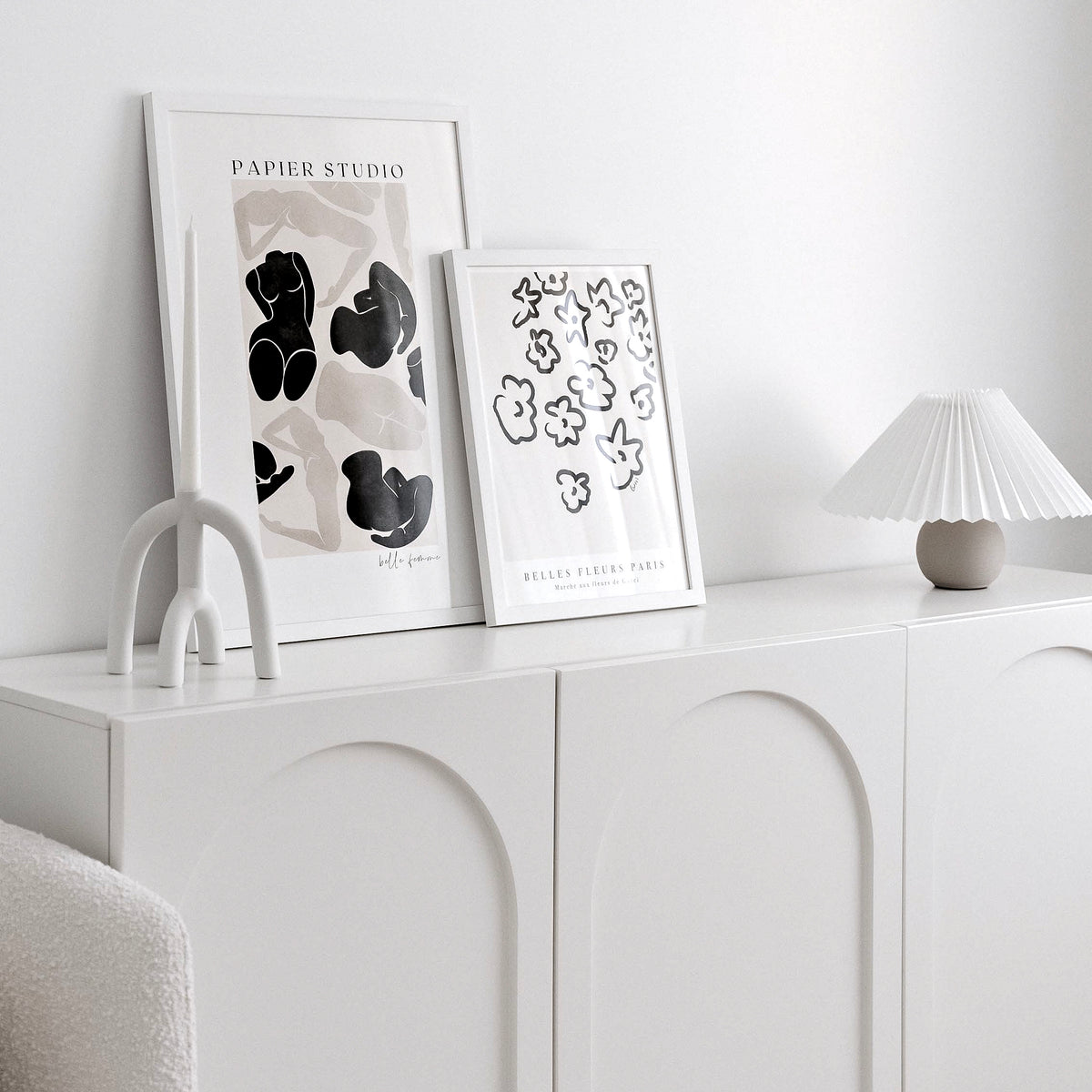 Belle Femme print in a white frame beside the Fleurs print on a white arched sideboard