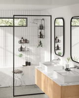 A modern bathroom with a black and white tiled wall featuring Umbra's Cubiko Shower Bins, Set of 2, with a bent wire design.