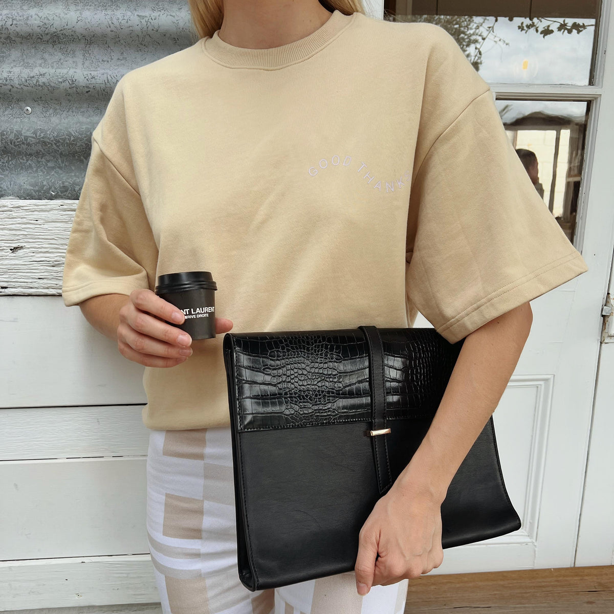 Woman holding the Black Penelope laptop sleeve with papers inside