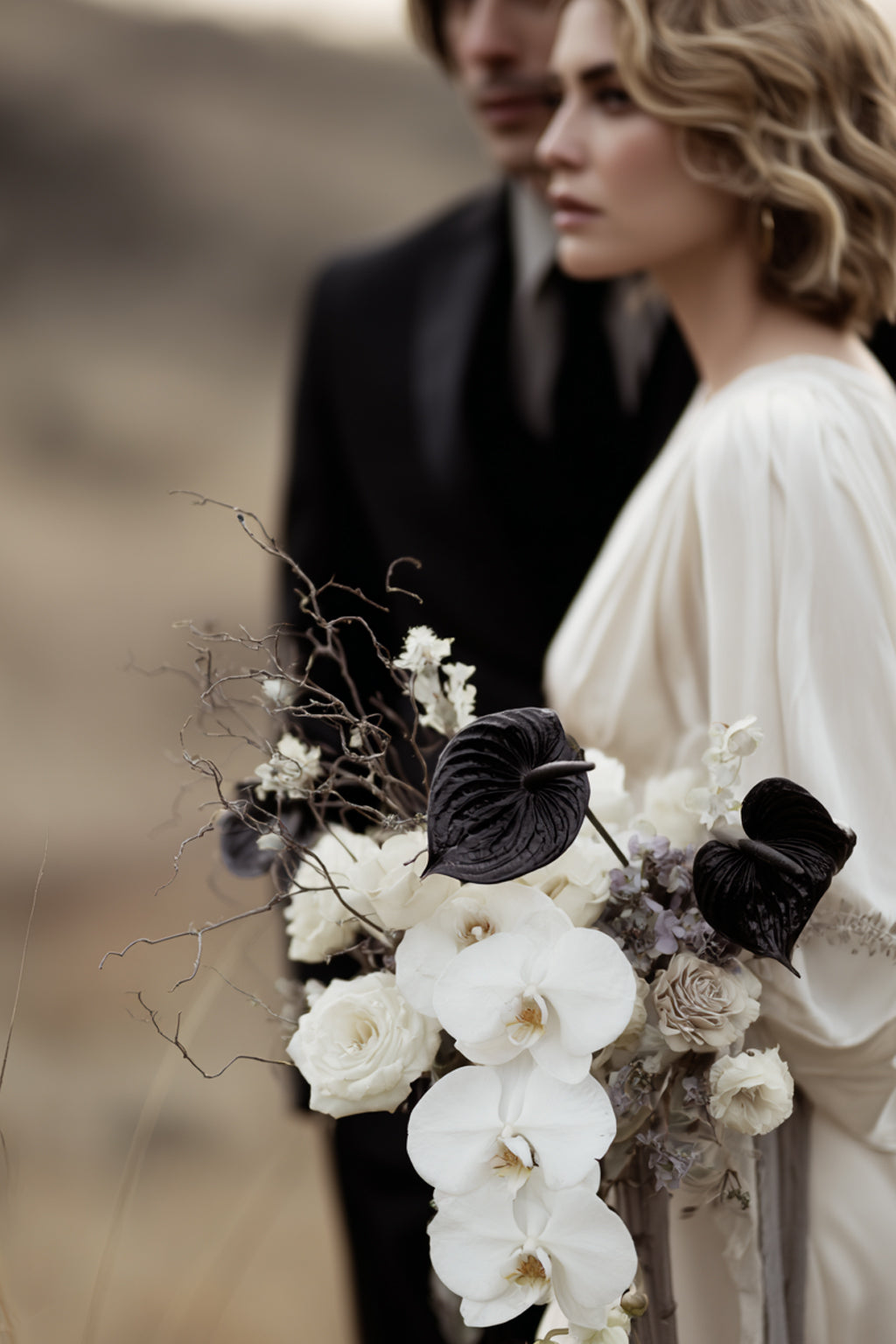 Bride and groom with a bouquet of white orchids and black anthuriums