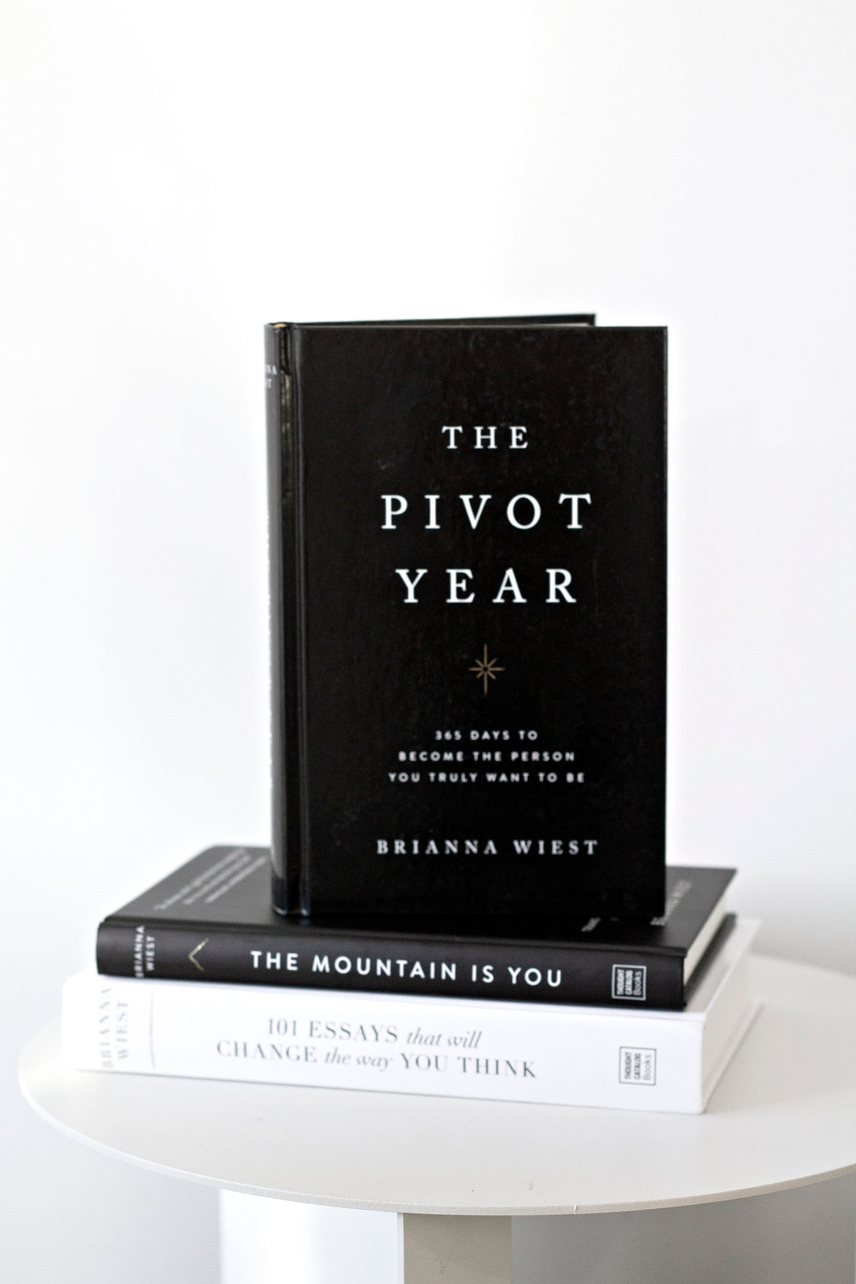 The Pivot Year standing upright on a stack of two other titles on a round white table