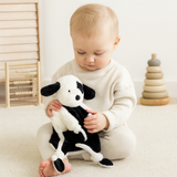 Baby holding a Buster the Puppy comforter by Lily & George styled in a calm, Scandinavian nursery